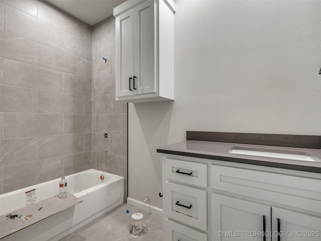 bathroom with tile patterned flooring, tiled shower / bath combo, and vanity