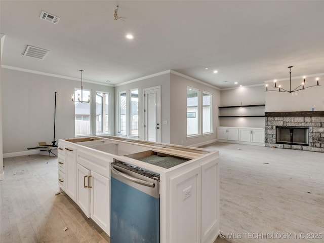 kitchen with white cabinetry, a chandelier, a kitchen island, pendant lighting, and stainless steel dishwasher