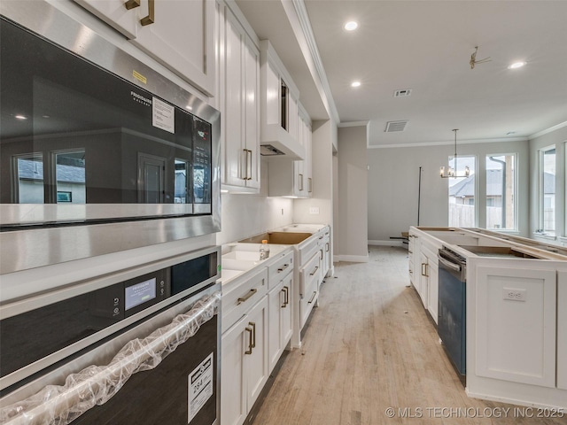 kitchen with decorative light fixtures, an inviting chandelier, light hardwood / wood-style flooring, ornamental molding, and white cabinets