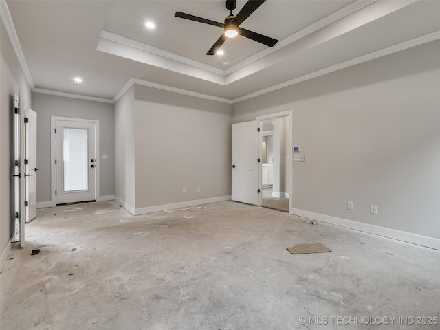 empty room with a raised ceiling, ceiling fan, and ornamental molding