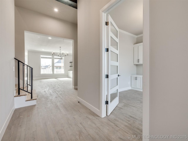 hall with ornamental molding, a chandelier, and light hardwood / wood-style flooring