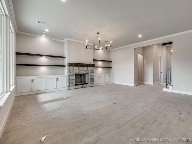 unfurnished living room featuring crown molding, light wood-type flooring, a stone fireplace, and a chandelier