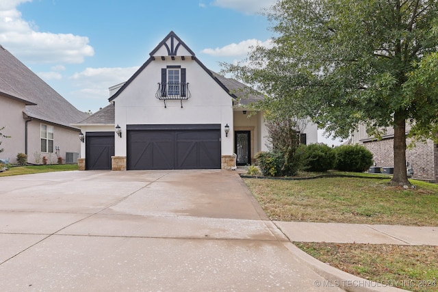 view of front of house with a garage, central air condition unit, and a front yard