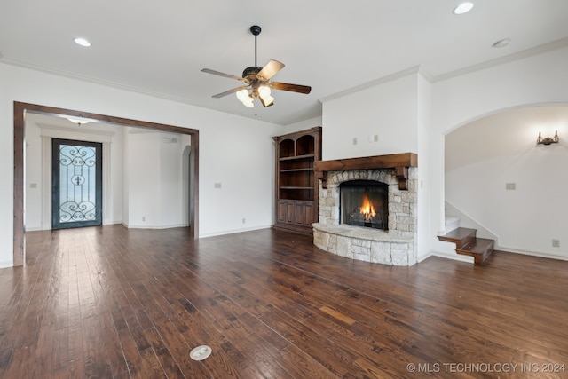 unfurnished living room with a fireplace, dark hardwood / wood-style floors, ceiling fan, and ornamental molding