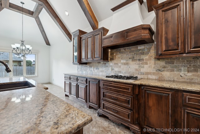 kitchen with pendant lighting, premium range hood, sink, tasteful backsplash, and stainless steel gas cooktop