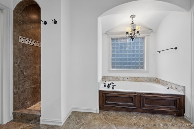 bathroom featuring tile patterned flooring, plus walk in shower, and an inviting chandelier