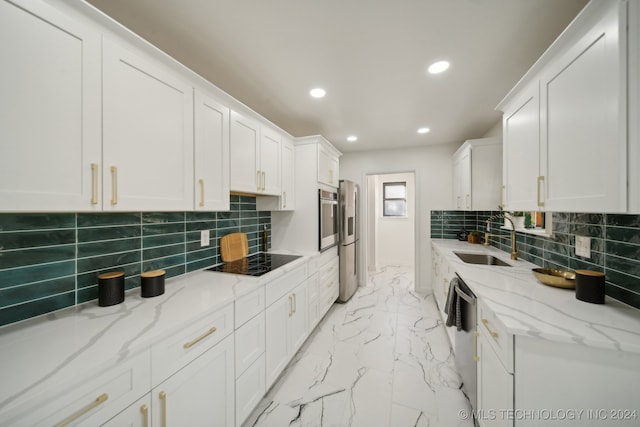 kitchen featuring white cabinets, sink, decorative backsplash, light stone countertops, and stainless steel appliances