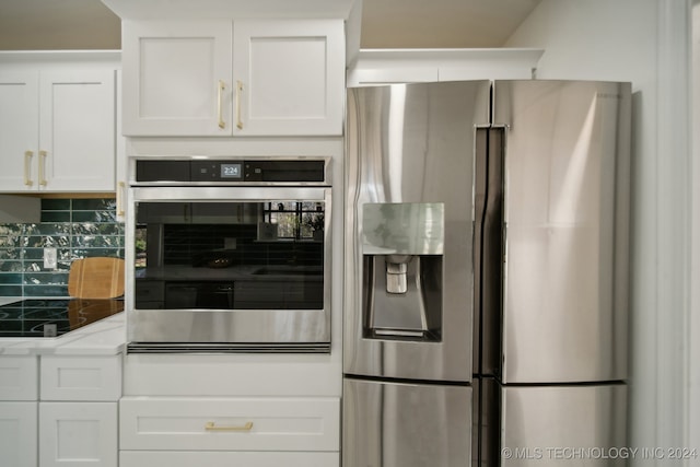 kitchen featuring light stone countertops, white cabinetry, stainless steel appliances, and tasteful backsplash