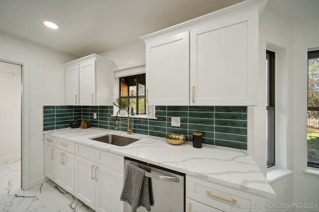 kitchen featuring light stone countertops, white cabinetry, sink, and stainless steel dishwasher