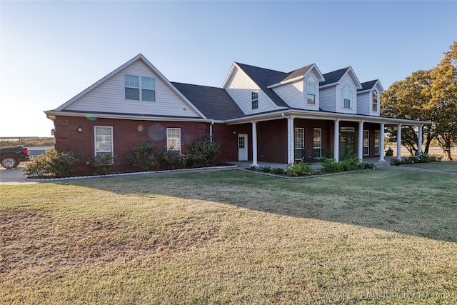 cape cod home featuring a porch and a front yard