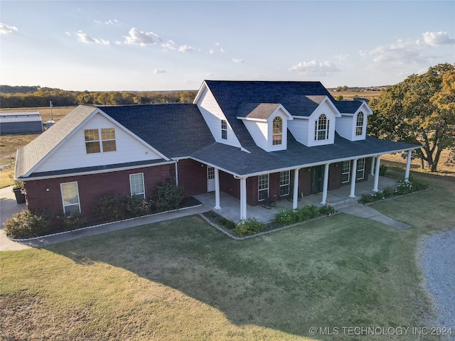 view of front of house with covered porch and a front lawn