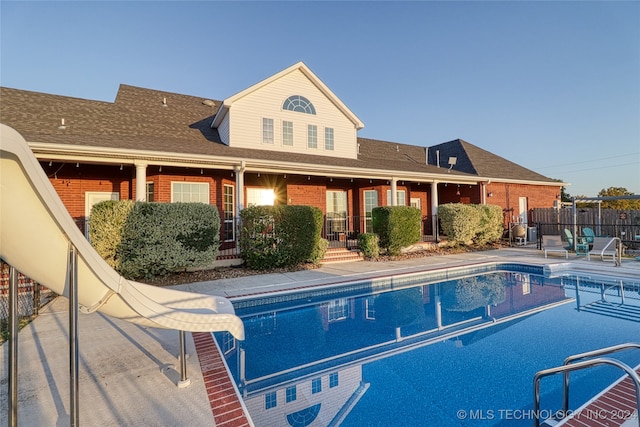 view of swimming pool with a patio area and a water slide