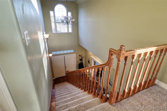 stairs with carpet and a chandelier