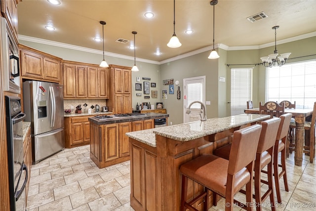 kitchen with pendant lighting, a chandelier, a center island with sink, and stainless steel appliances