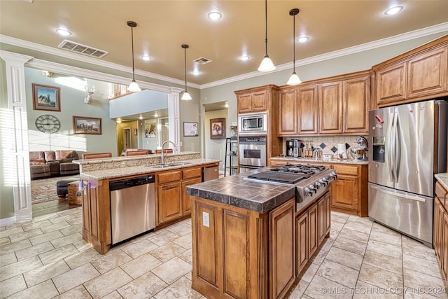 kitchen with crown molding, sink, hanging light fixtures, appliances with stainless steel finishes, and a kitchen island