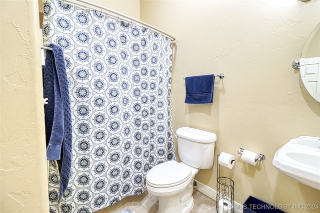 bathroom with tile patterned floors, curtained shower, sink, and toilet