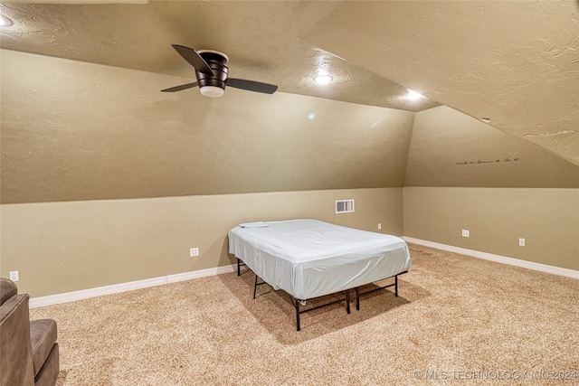 bedroom featuring carpet, a textured ceiling, vaulted ceiling, and ceiling fan