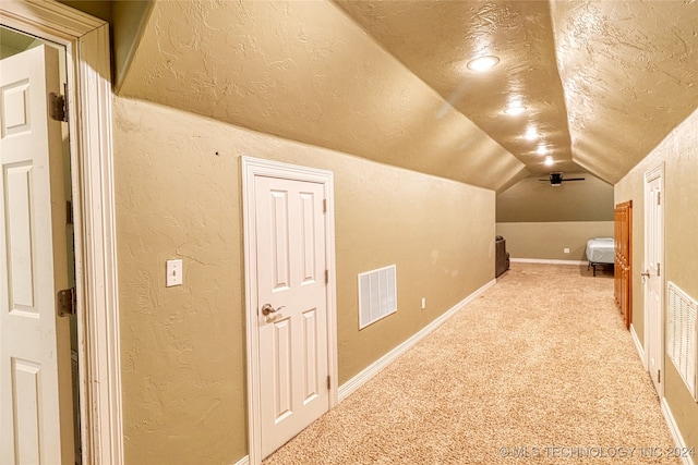 additional living space featuring carpet floors, a textured ceiling, and vaulted ceiling