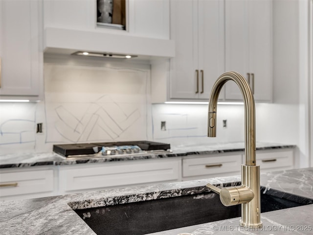 details with white cabinetry, backsplash, and light stone counters