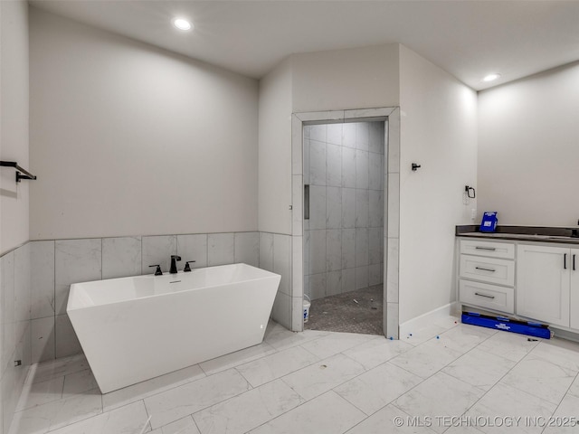 bathroom with vanity and shower with separate bathtub