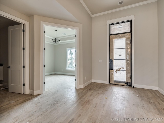 entryway featuring light hardwood / wood-style flooring, ornamental molding, and a notable chandelier