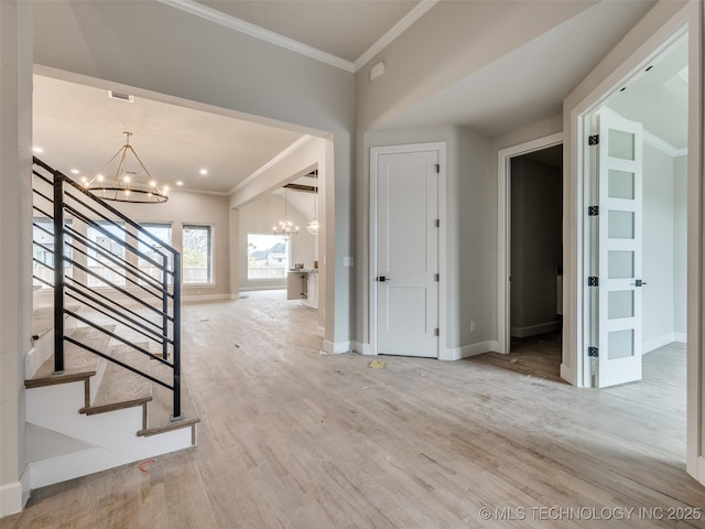 foyer entrance featuring crown molding, wood-type flooring, and a notable chandelier