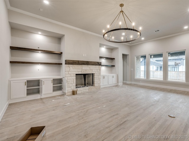 unfurnished living room featuring a fireplace, built in features, ornamental molding, and light hardwood / wood-style floors