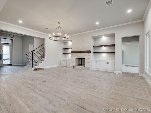 unfurnished living room featuring crown molding, a stone fireplace, and a chandelier