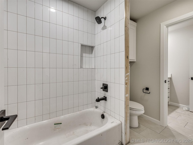 bathroom featuring tile patterned floors, toilet, and tiled shower / bath