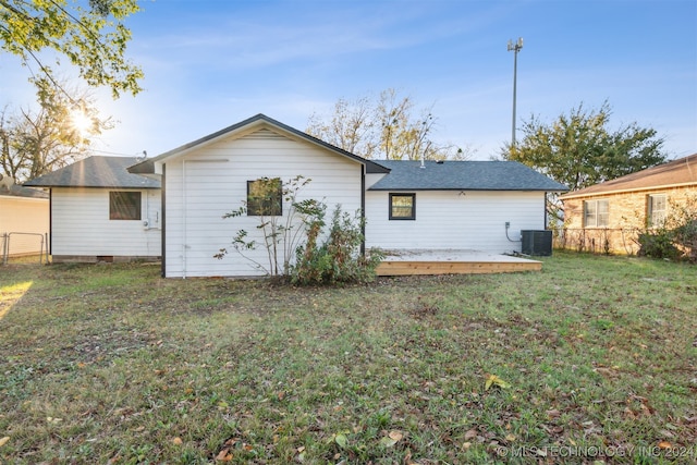 rear view of house featuring a lawn, central air condition unit, and a wooden deck