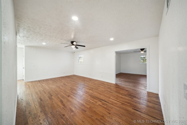 spare room featuring ceiling fan, dark wood-type flooring, and a textured ceiling