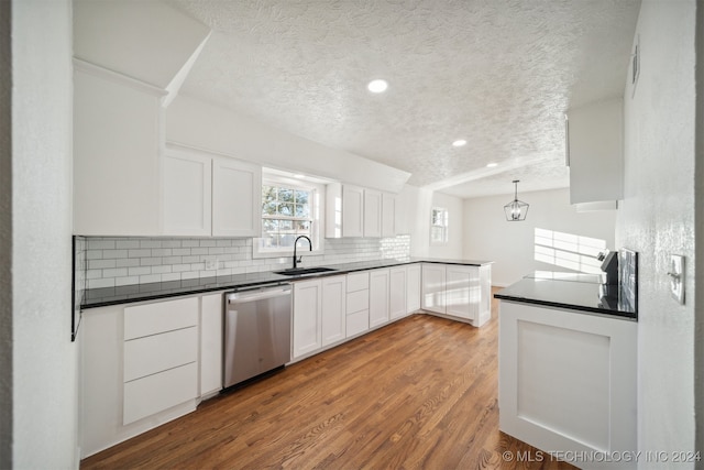 kitchen featuring sink, dishwasher, light hardwood / wood-style floors, white cabinetry, and hanging light fixtures