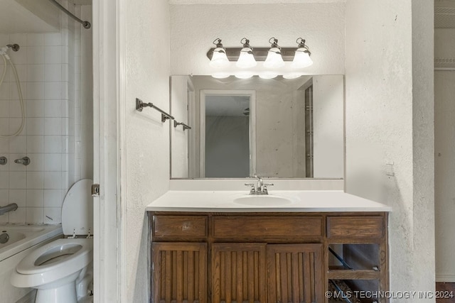 full bathroom with toilet, vanity, and tiled shower / bath combo