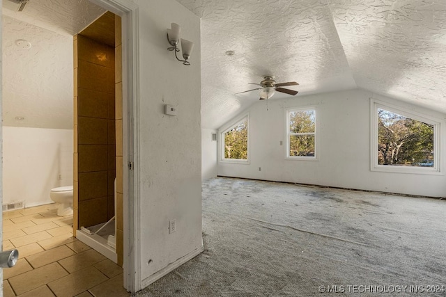 bonus room featuring ceiling fan, light colored carpet, lofted ceiling, and a textured ceiling