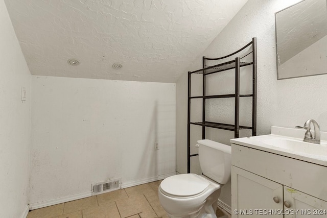 bathroom with tile patterned flooring, a textured ceiling, lofted ceiling, toilet, and vanity