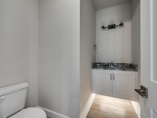 bathroom with vanity, toilet, and hardwood / wood-style floors