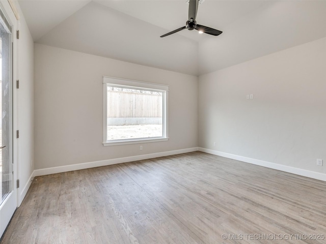 spare room with ceiling fan, vaulted ceiling, and light wood-type flooring