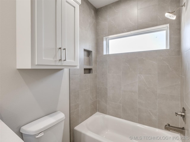 bathroom featuring toilet and tiled shower / bath