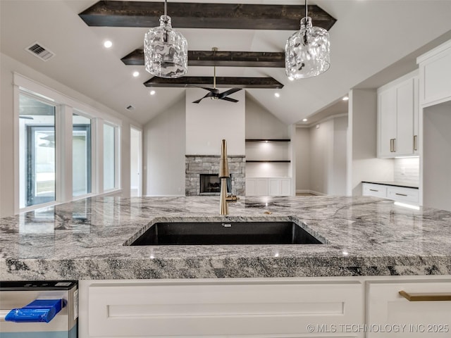 kitchen featuring white cabinetry, light stone countertops, dishwashing machine, and lofted ceiling with beams