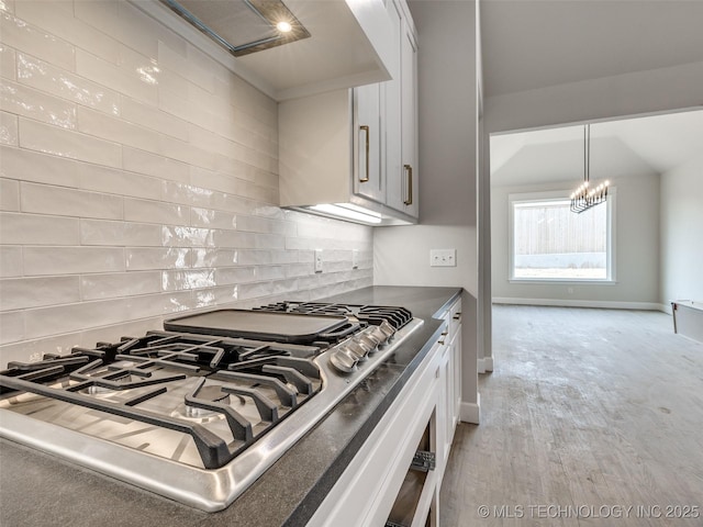 kitchen featuring white cabinetry, pendant lighting, tasteful backsplash, and light hardwood / wood-style floors