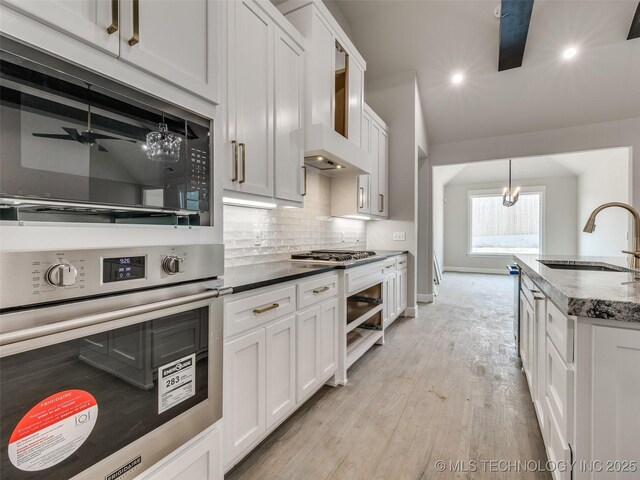 kitchen featuring sink, hanging light fixtures, white cabinets, and appliances with stainless steel finishes