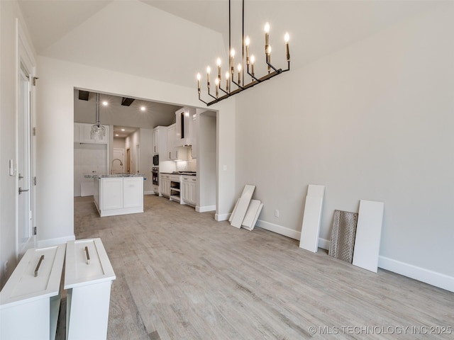 interior space featuring vaulted ceiling, sink, and light wood-type flooring