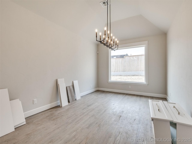 interior space featuring lofted ceiling, an inviting chandelier, and light hardwood / wood-style flooring