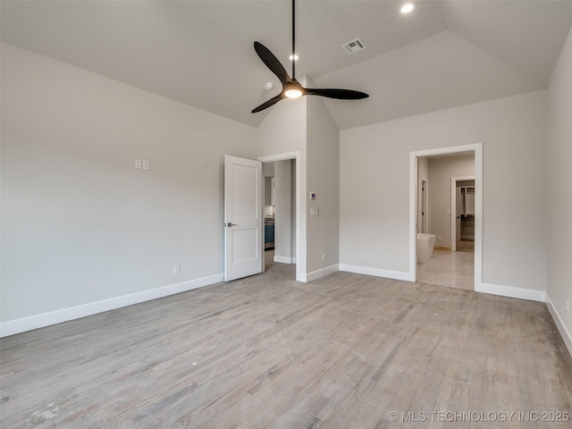 unfurnished bedroom featuring ceiling fan, vaulted ceiling, ensuite bath, and light hardwood / wood-style flooring