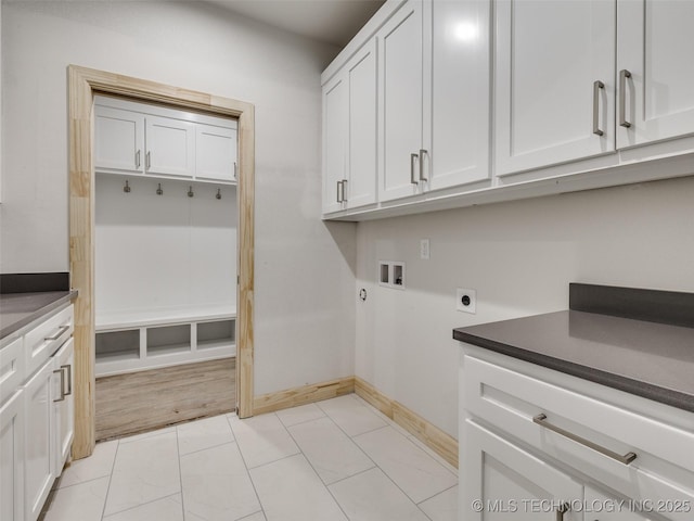 laundry room featuring cabinets, electric dryer hookup, washer hookup, and light tile patterned floors