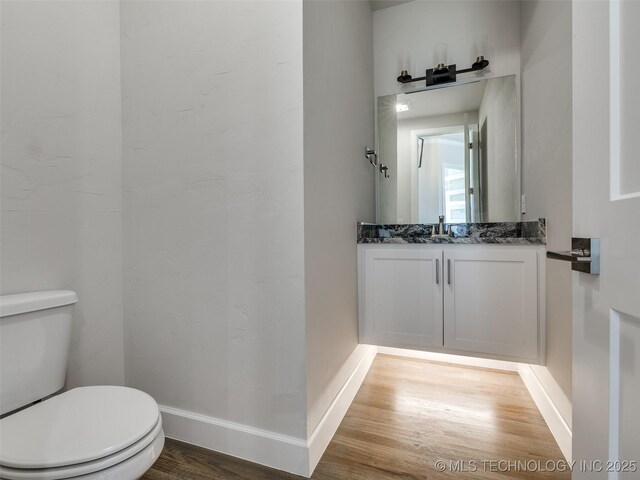 11224 S Fir Ave W, Jenks, OK 74037 - half bathroom featuring wood finished floors, toilet, vanity, and baseboards