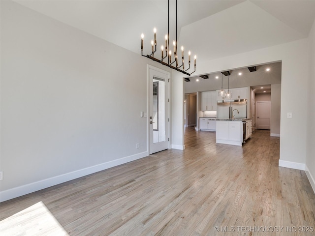 11224 S Fir Ave W, Jenks, OK 74037 - unfurnished living room featuring light wood finished floors, baseboards, a sink, a chandelier, and lofted ceiling