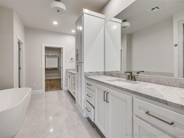 11224 S Fir Ave W, Jenks, OK 74037 - bathroom with vanity, a freestanding tub, recessed lighting, and baseboards