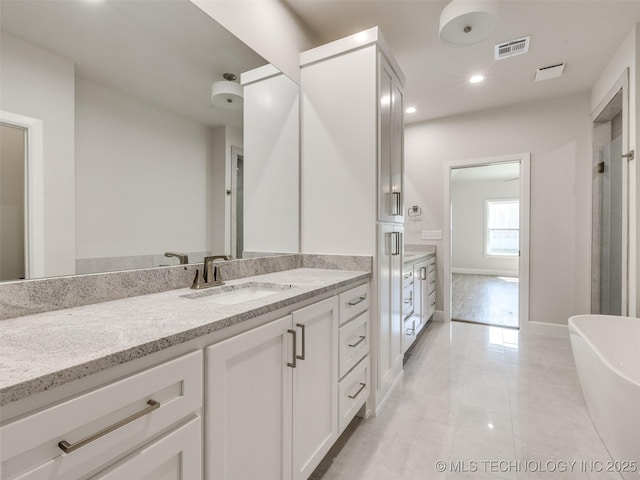 11224 S Fir Ave W, Jenks, OK 74037 - full bathroom with vanity, marble finish floors, a freestanding tub, recessed lighting, and baseboards