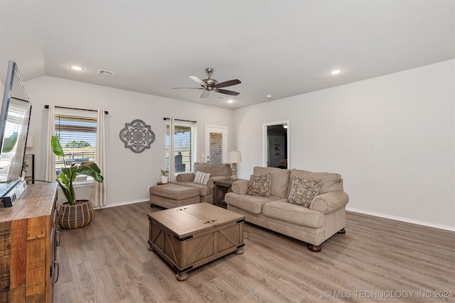 living room with ceiling fan, a healthy amount of sunlight, lofted ceiling, and light hardwood / wood-style flooring